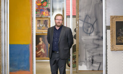 Portrait of Eric Crosby standing in the painting storage area of Carnegie Museum of Art