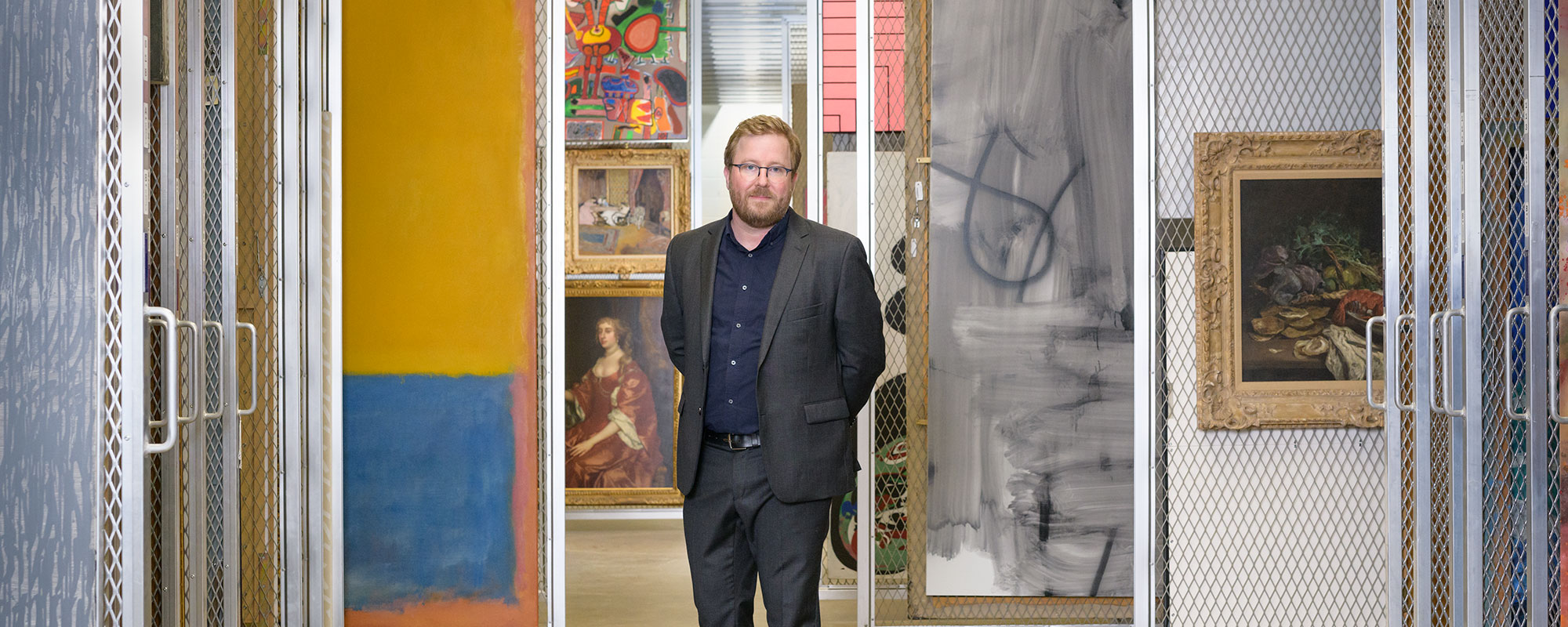 Portrait of Eric Crosby standing in the painting storage area of Carnegie Museum of Art