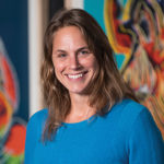 Portrait of Nicole Heller standing in front of Andy Warhol's Endangered Species paintings