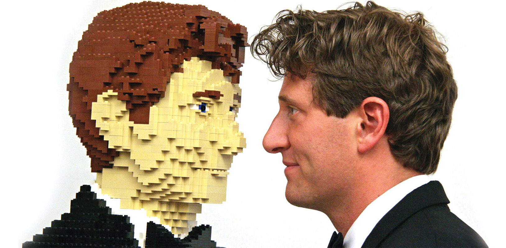 The artist facing to face with a replica of himself made from lego bricks.