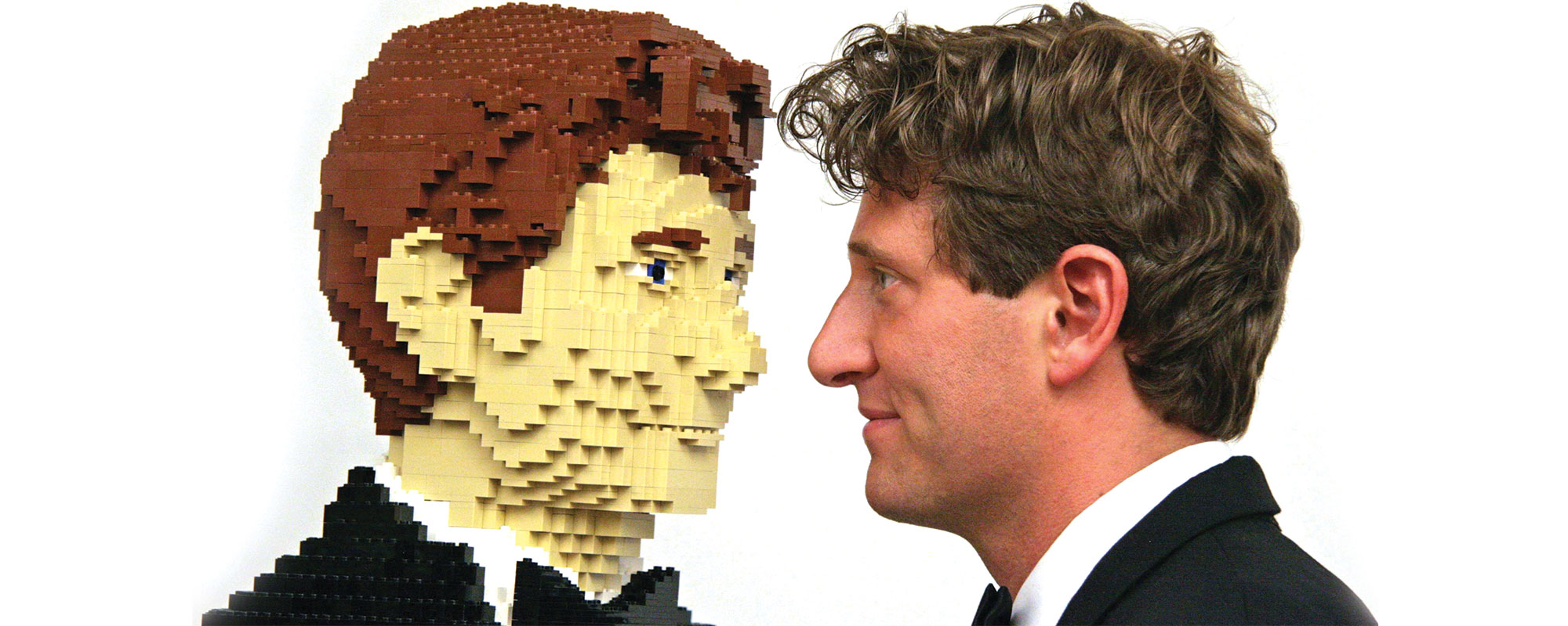 The artist facing to face with a replica of himself made from lego bricks.