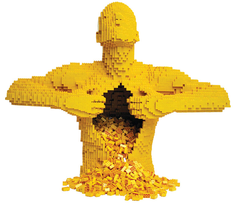 a sculpture made from yellow legos of a man pulling his chest open with legos spilling out