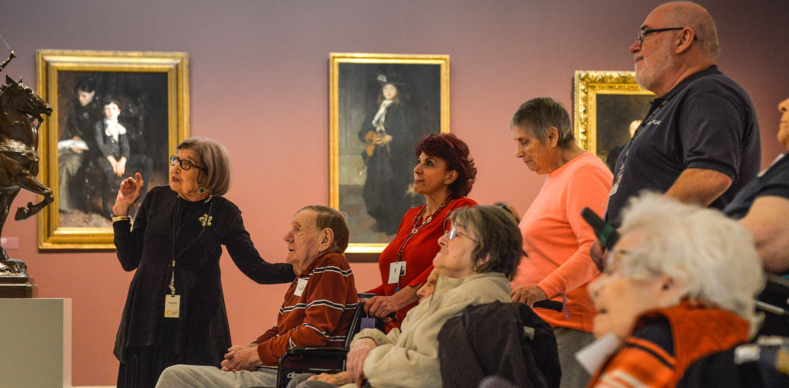 A docent leading a group of Alzheimer patients on a tour of an art gallery