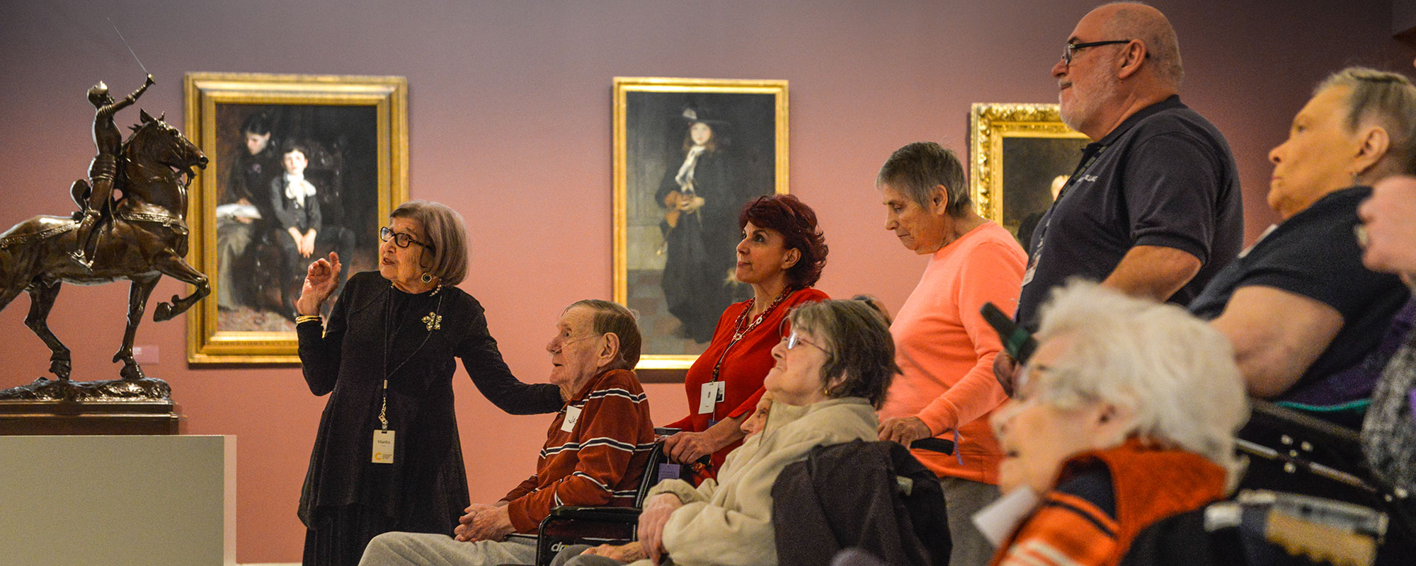 A docent leading a group of Alzheimer patients on a tour of an art gallery