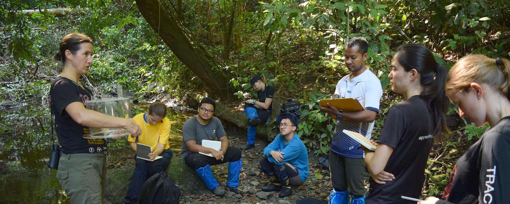 a woman instructs a group of graduate students on in the rainforests of Malaysian Borneo.