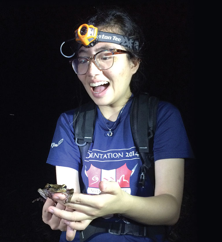 A female college student holding a frog