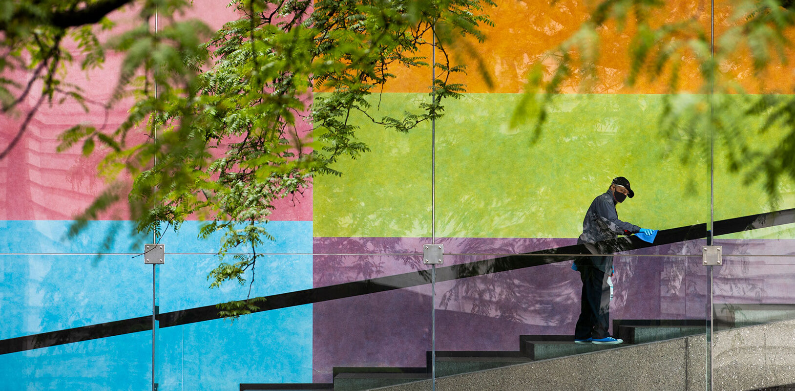Custodian J.W. Williams, who has worked at Carnegie Museums for 38 years, sanitizes the handrail leading up to the Scaife Galleries at Carnegie Museum of Art.