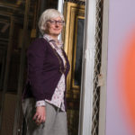 Portrait ohoto fo Elizabeth Tufts Brown standing in art storage area.