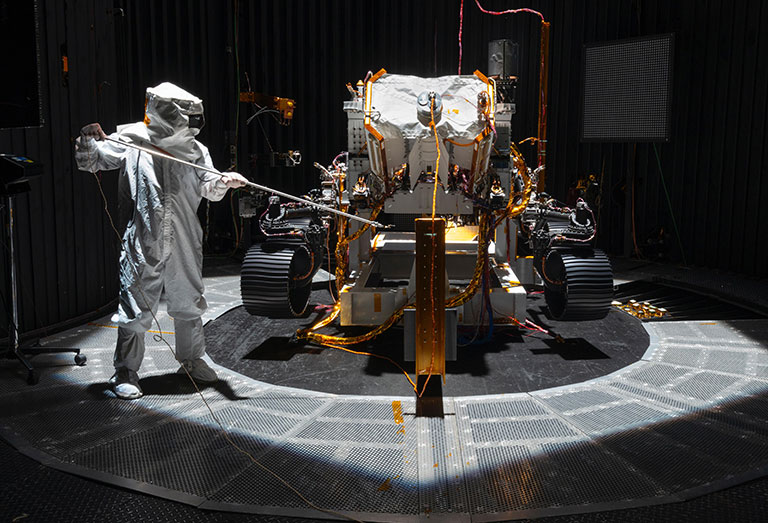 A NASA engineer in a hazmat suit preparing the rover for its mission