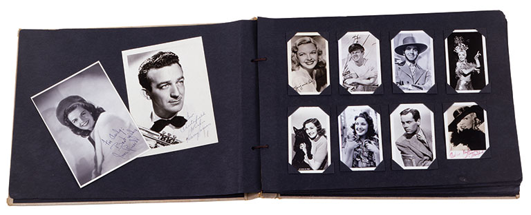 A scrapbook opened up showing black and white photos of celebrities