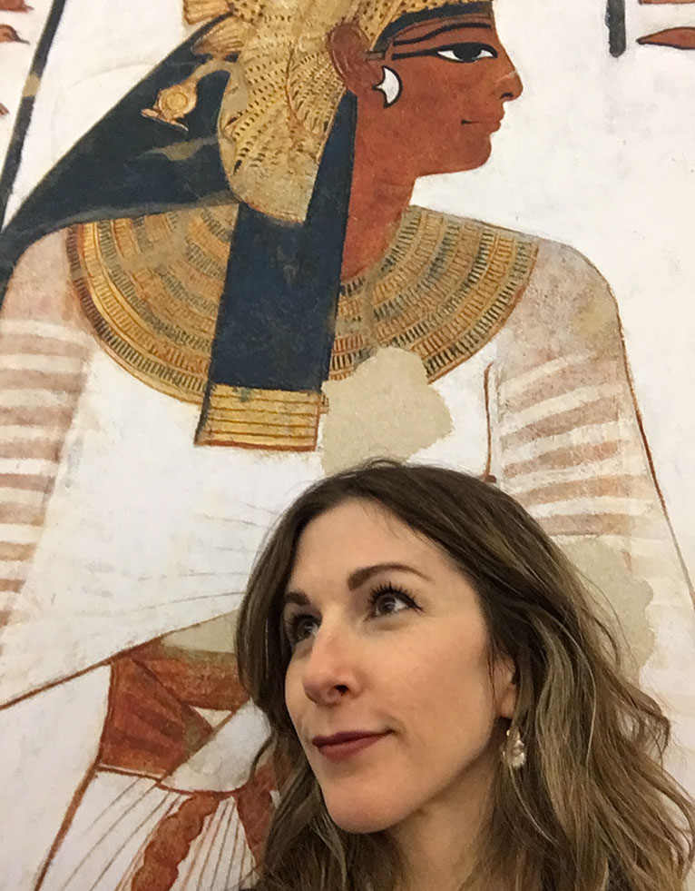 A woman in front of an Egyptian painting