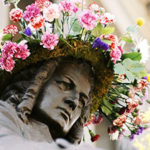 A sculpture of Bach with a wreath of flowers on his head
