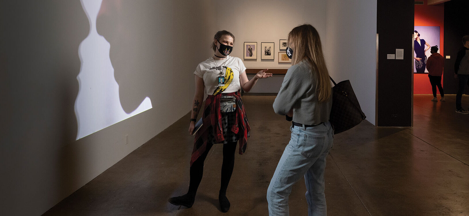 A gallery assistant at the Warhol museum speaking with a museum visitor