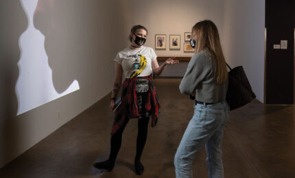 A gallery assistant at the Warhol museum speaking with a museum visitor
