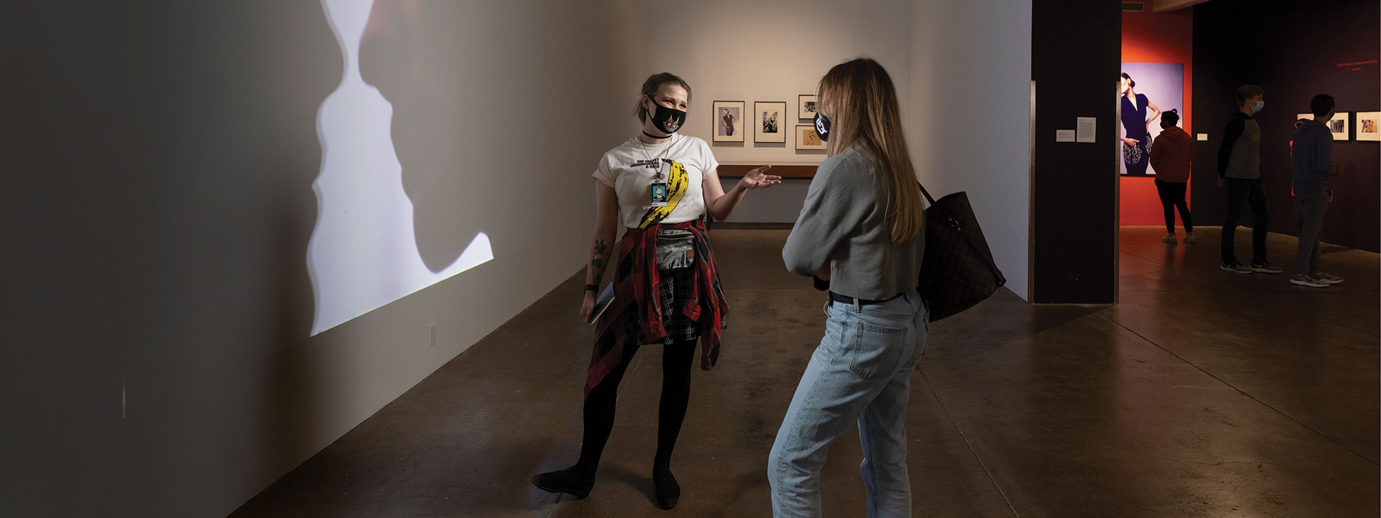 A gallery assistant at the Warhol museum speaking with a museum visitor
