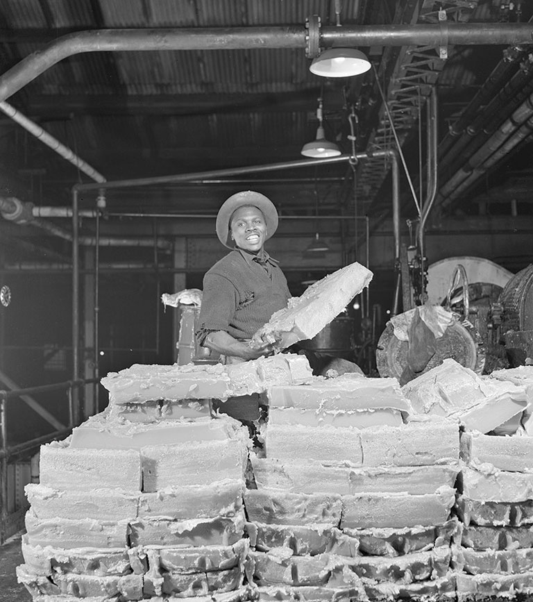 A man stacking bricks of solid grease.