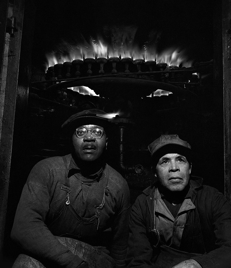 2 men working beneath a burner.