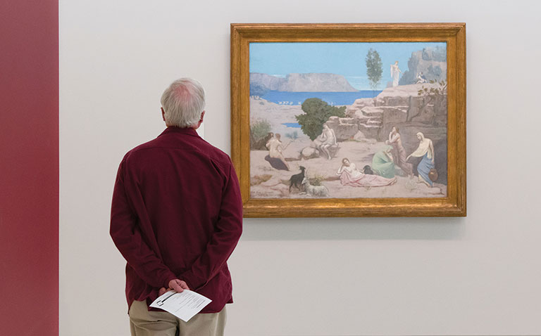 an older man looking at ta painting in the museum