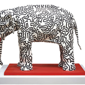 A large plaster elephant with black figures painted on it.