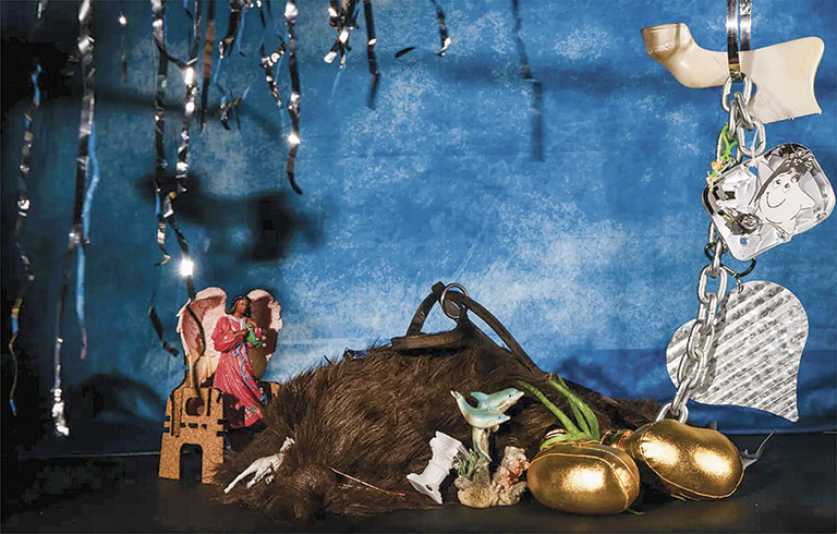 A whimsical arrangement of eclectic items including figurines, golden eggs, and a chain, set against a blue backdrop.