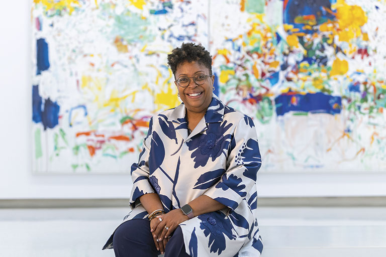 Woman sitting in front of colorful abstract art