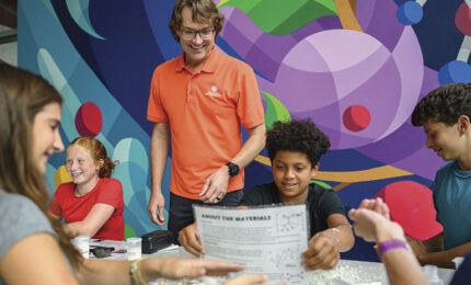 Teenagers and teacher in classroom with colorful mural