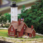 Miniature model of a red house with white lighthouse