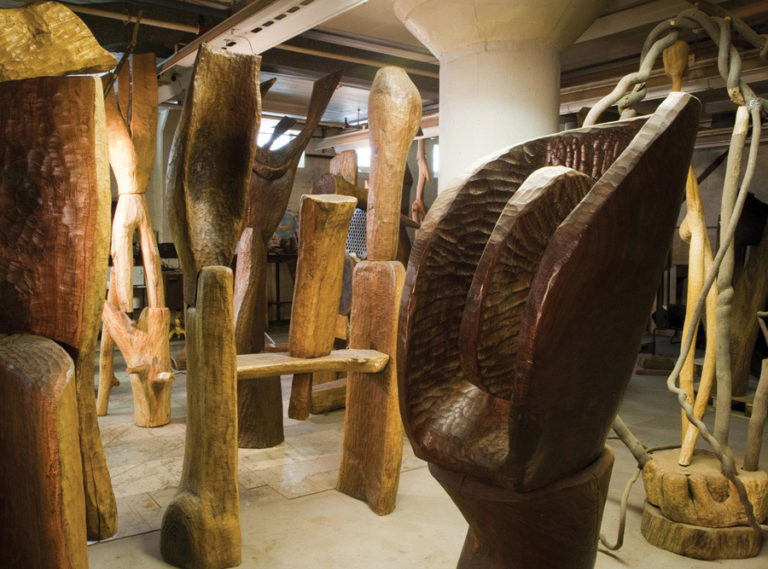 artists's studio full of large wooden sculptures