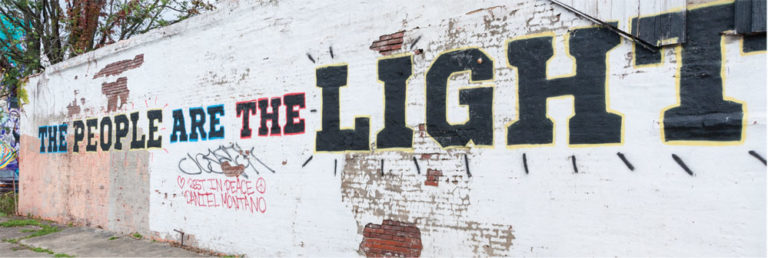 The words the People are the Light painted onto a wall of an old building