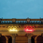 An exterior view of the museum showing the neon names that wrap around the perimeter.