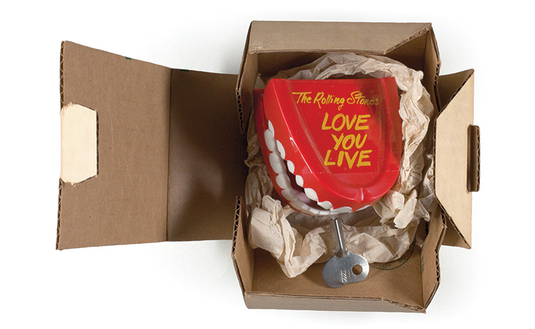 A box containing toy teeth with the words, The Rolling Stones, Love you live.