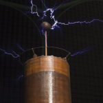 A tesla coil with sparks shooting from the ball on top.