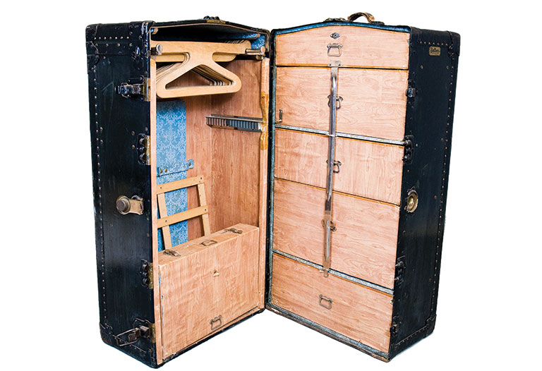 A large vintage trunk, opened to show the inside.