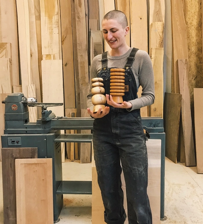 Hanna Dausch holding some of her wood artwork pieces