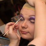 A teen having make-up applied to her face.