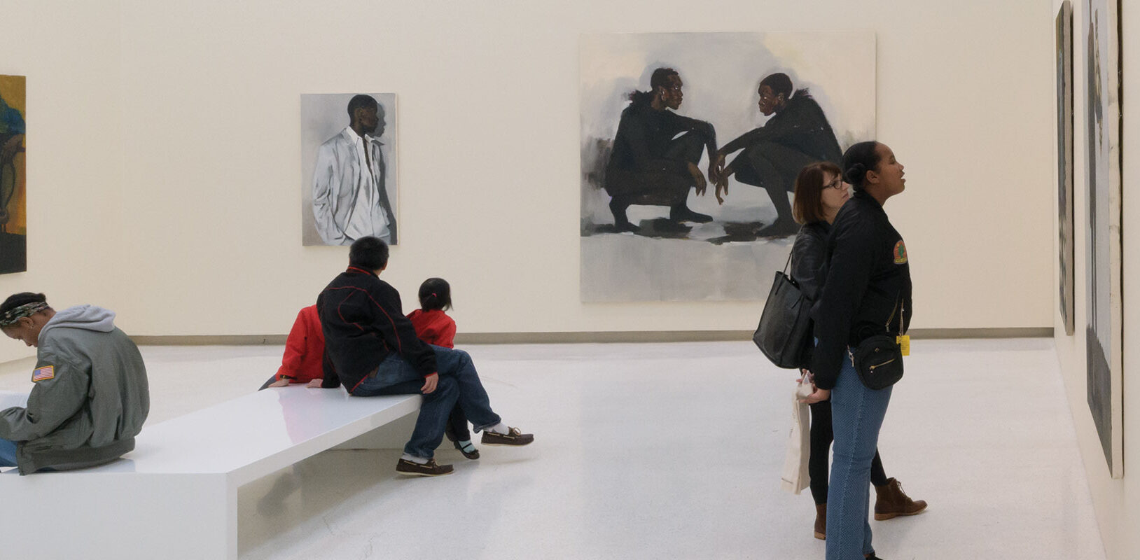 People in an art museum gallery looking at paintings