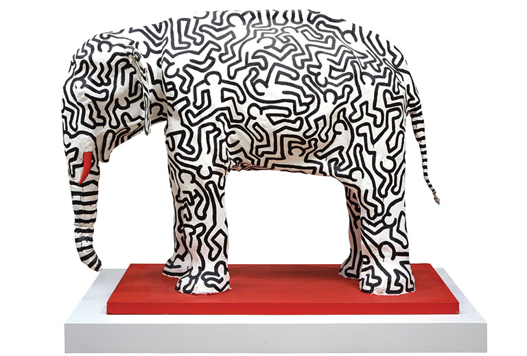 Paper mache elephant with black outlined figures