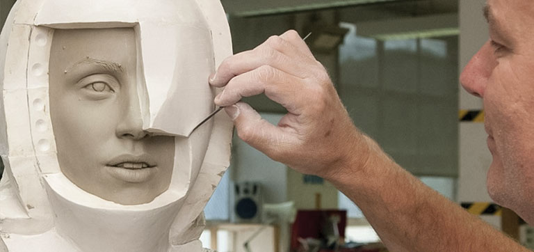 A man sculpting a wax human head