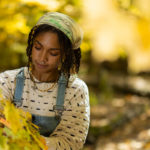 Nyjah Cephas looking at the leaves on a tree