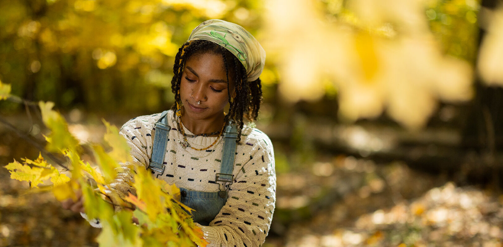 Nyjah Cephas looking at the leaves on a tree