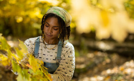 Nyjah Cephas looking at the leaves on a tree