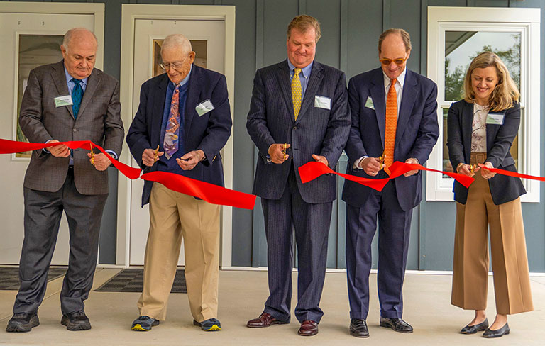 Five people at a ribbon cutting ceremony