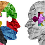 Two human head silouettes facing each other with puzzle pieces inset on them