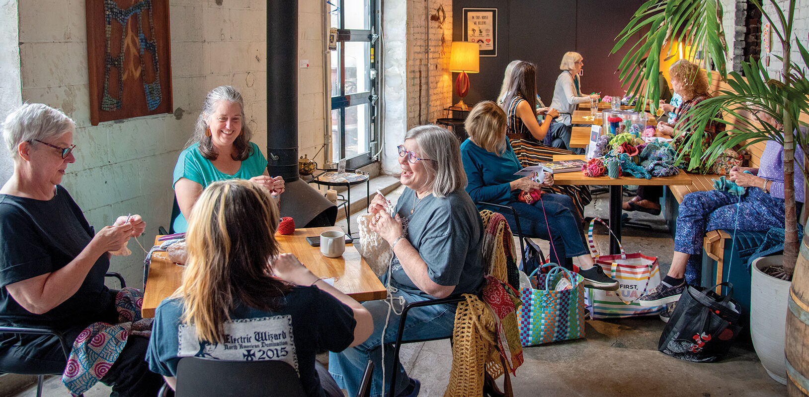 a group of woman crocheting in a local restaurant using colorful yarn