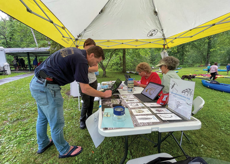 A man looking at a display on a table at. on outside event.