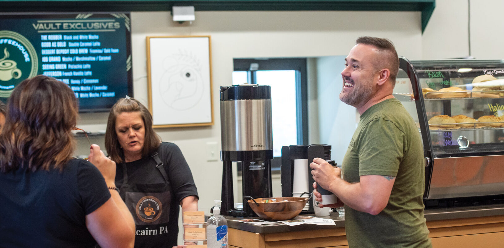 A group of people talking and laughing in a coffee shop