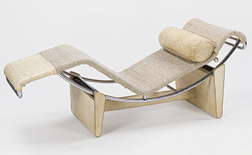 Curved, modern chaise lounge with a chrome frame, beige woven fabric, and a cylindrical pillow. The design is minimalist and elegant.