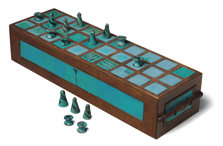 Ancient wooden board game with turquoise squares and metal cone game pieces. Some pieces are on the board, others are beside it. Calm, historical feel.