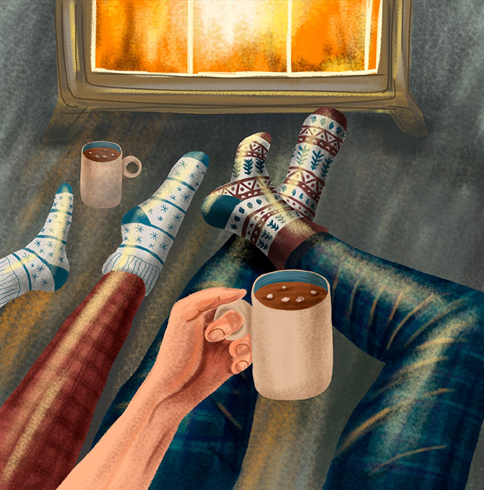 Cozy scene by a fireplace with two people in patterned socks and pajamas, holding mugs of cocoa, conveying warmth and relaxation.
