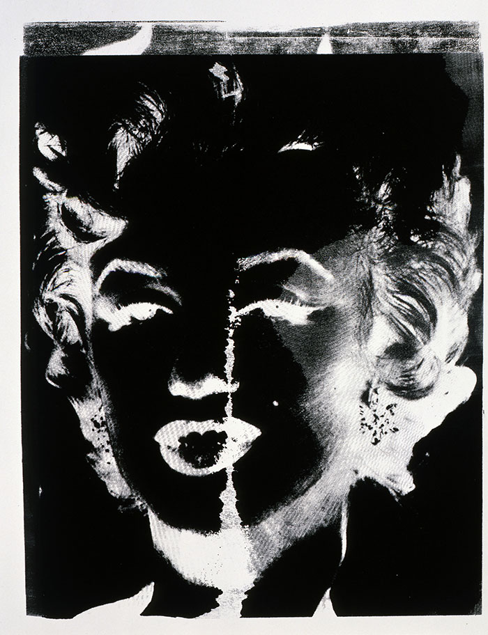 A high-contrast, black-and-white image of a woman's face, presented in a negative effect. The expression is dramatic, with bold shadows and highlights.
